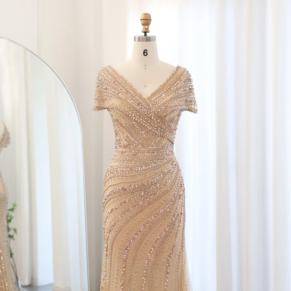 Silver nude mermaid gown with V-neck, intricate crystal beading, and sequin appliqués on a size 6 dress form.