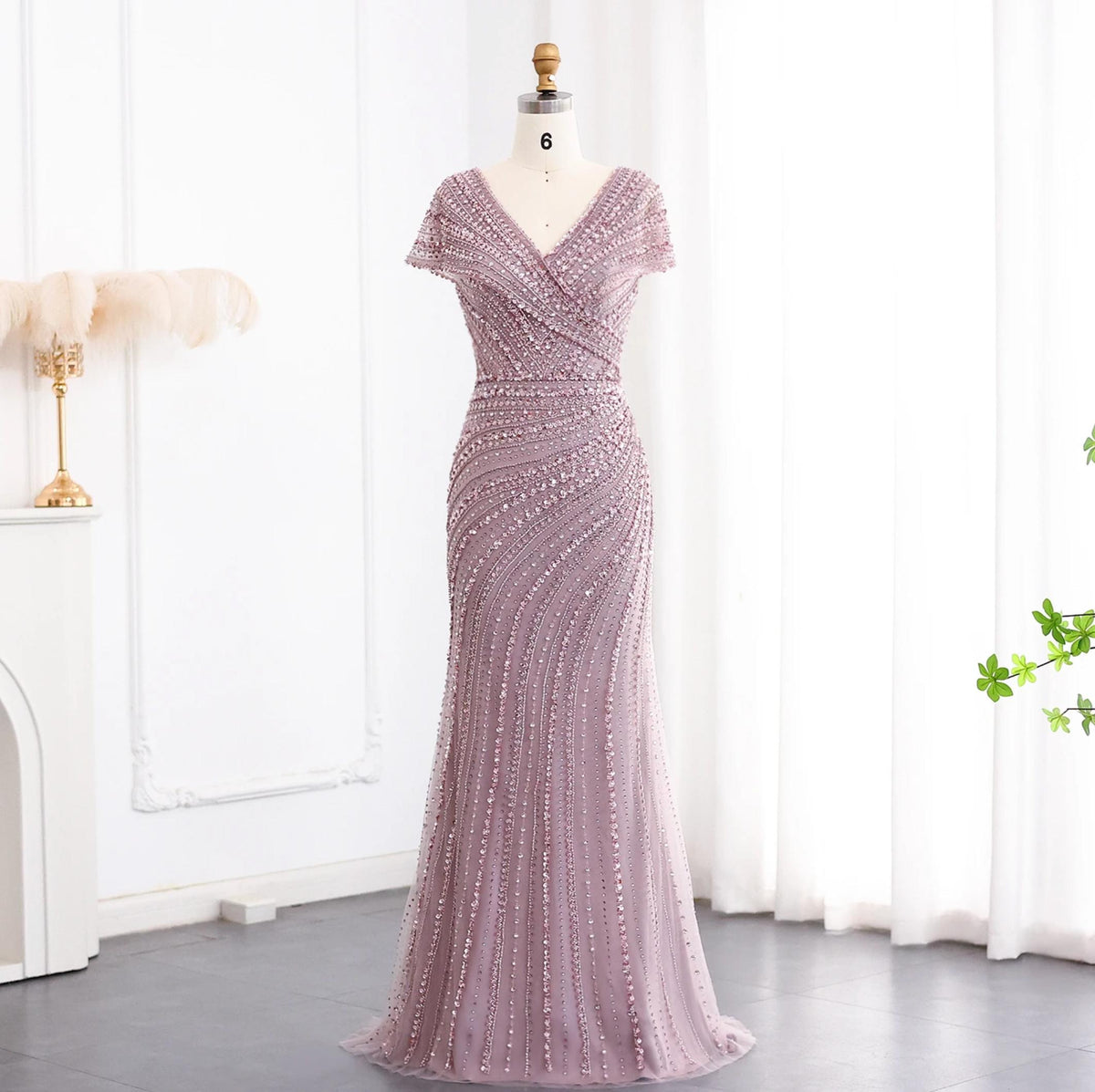 Silver nude mermaid gown with a V-neck, short sleeves, and intricate crystal and sequin beadwork on a mannequin.