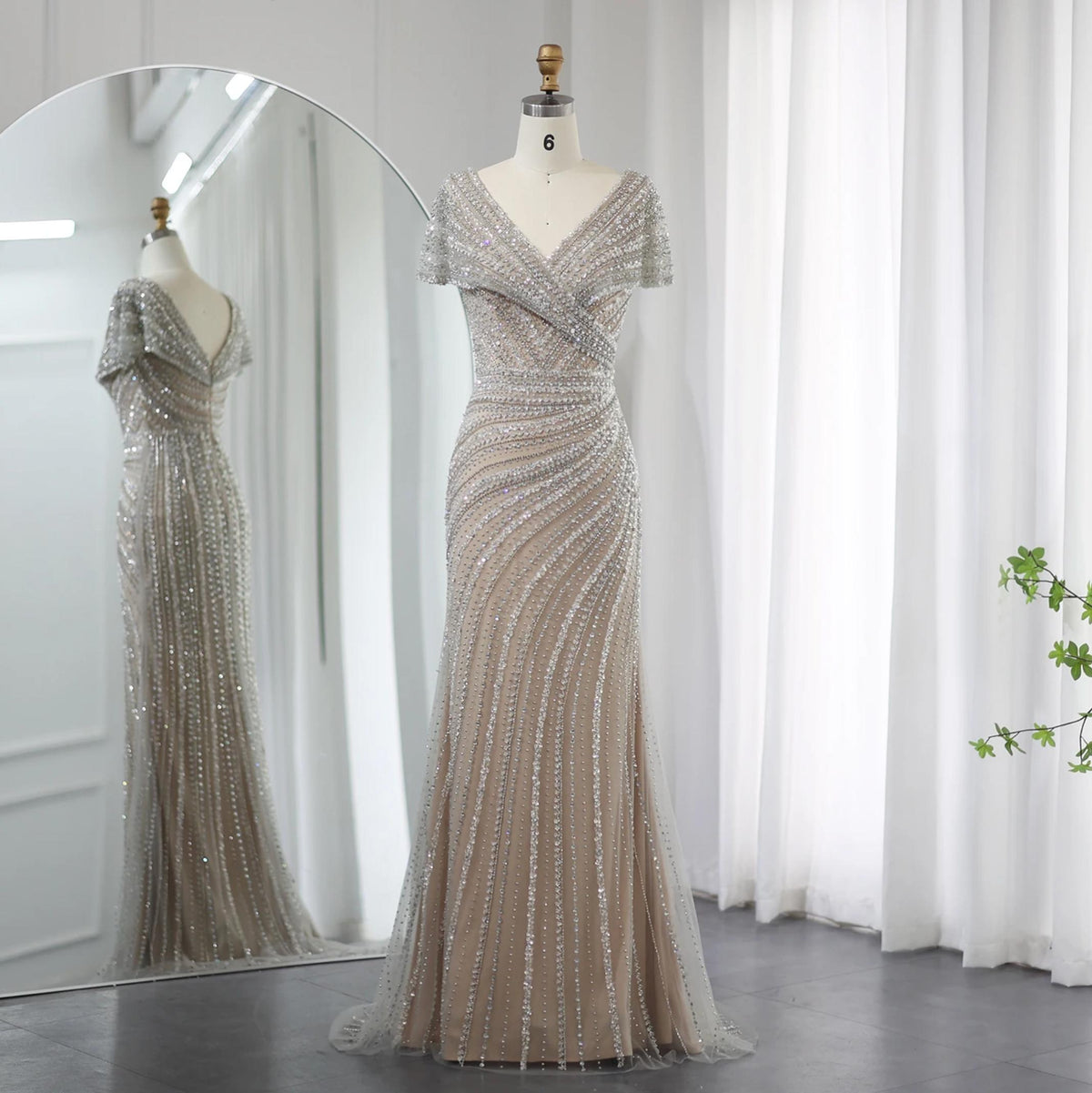 Silver nude mermaid gown with V-neck, short sleeves, and intricate crystal and sequin beadwork on a mannequin.