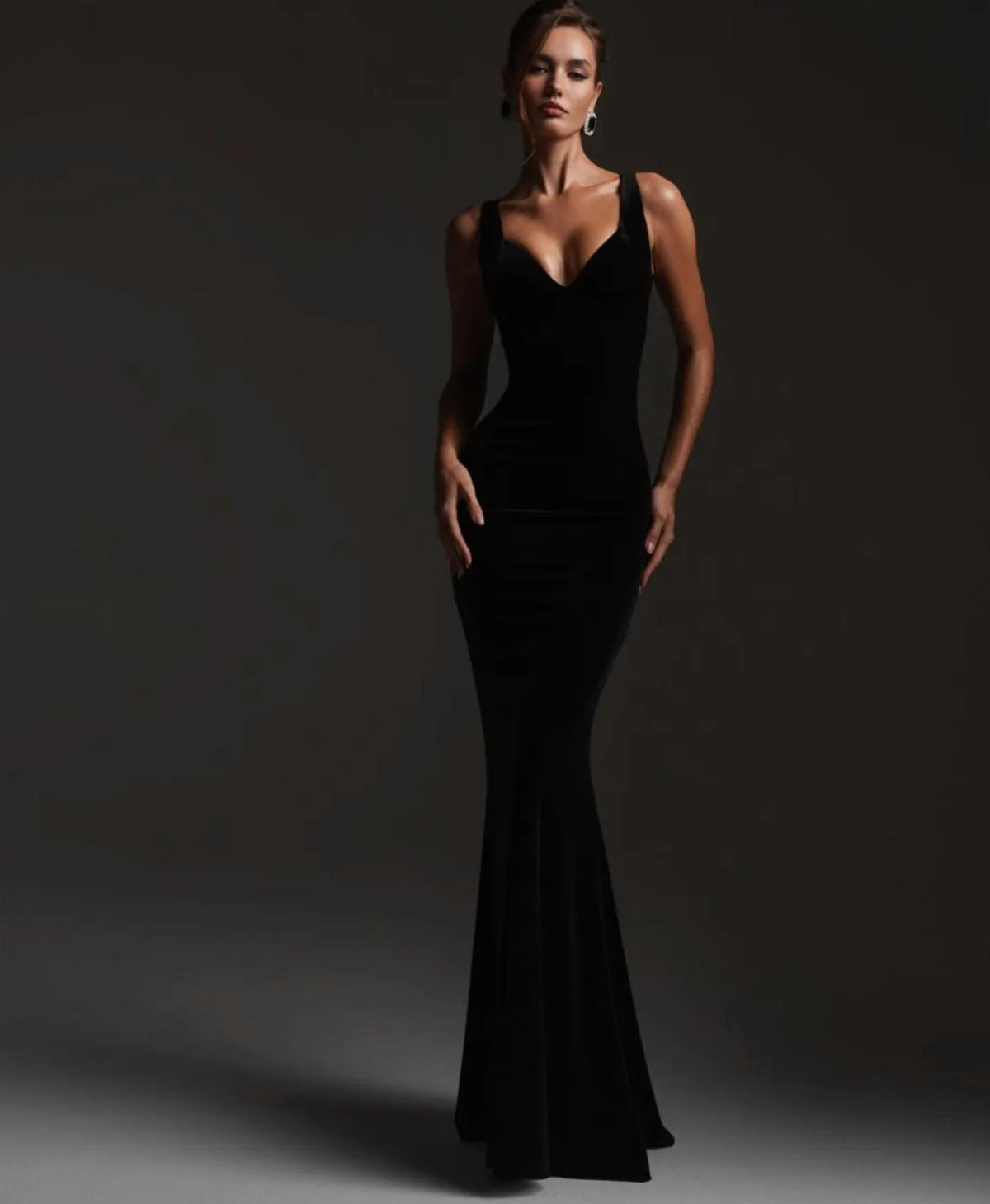 Elegant black velvet mermaid gown with a V-neckline and floor-length silhouette for formal evening wear.