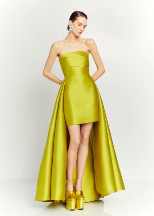 Strapless chartreuse mini dress with a dramatic detachable train and structured silhouette on a model.