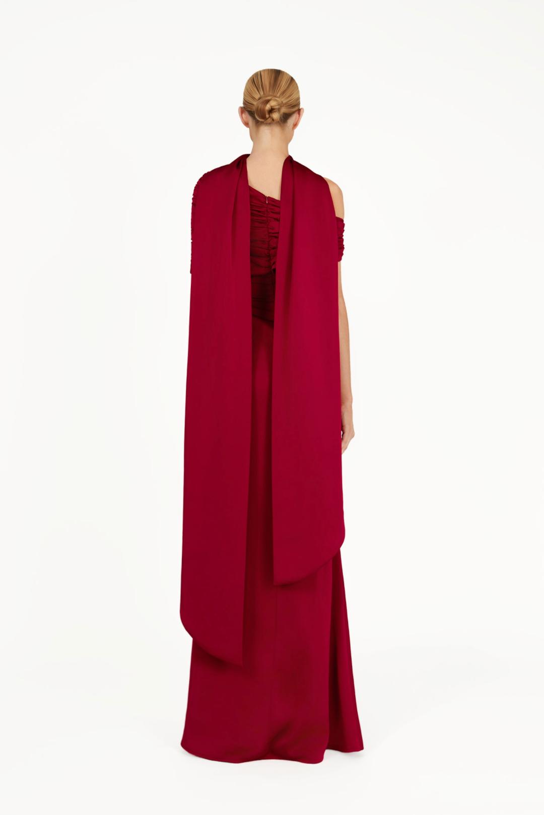 Back view of a floor-length red satin Kulture dress with a gathered Bardot neckline and elegant draped cape detail.