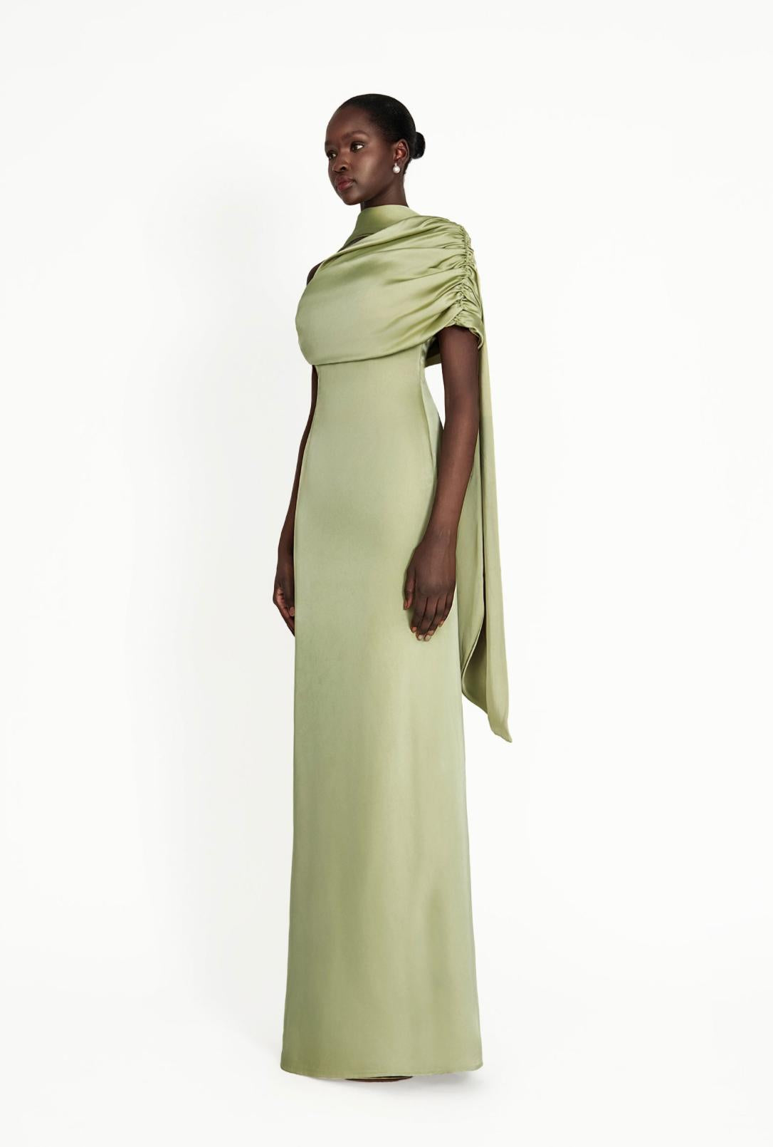 Sage green satin Kulture dress with a gathered Bardot neckline and flowing A-line silhouette on a model.