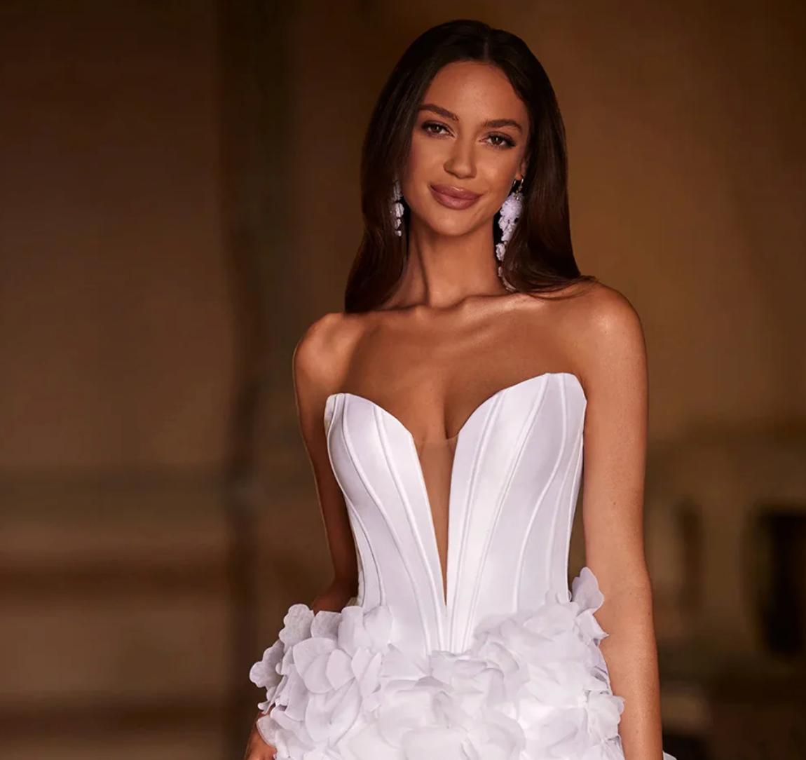 White sleeveless mini party dress with a sweetheart neckline, structured bodice, and handmade floral tulle detailing.
