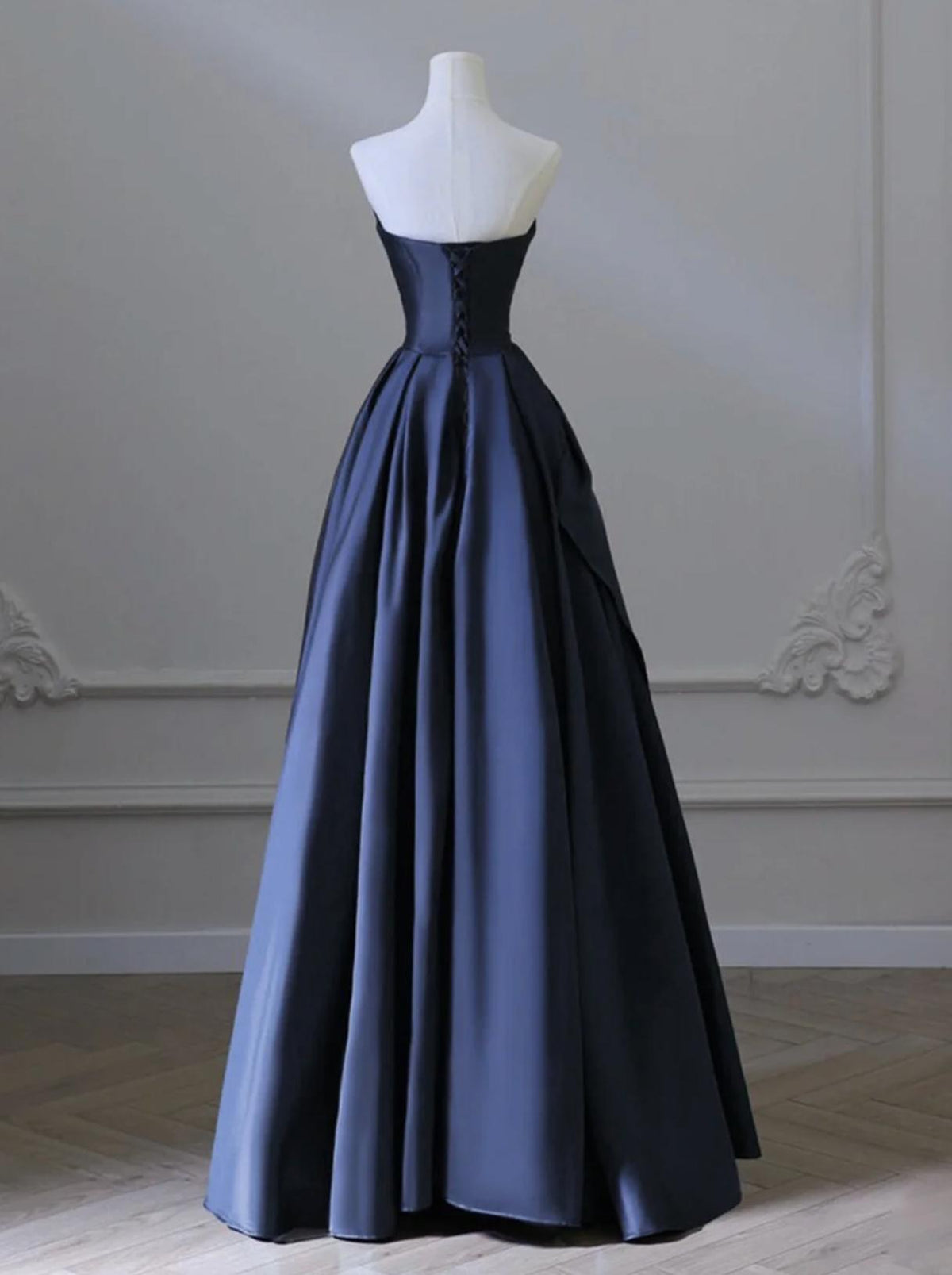 Elegant navy blue satin A-line gown with a sweetheart neckline and lace-up corset back on a mannequin.