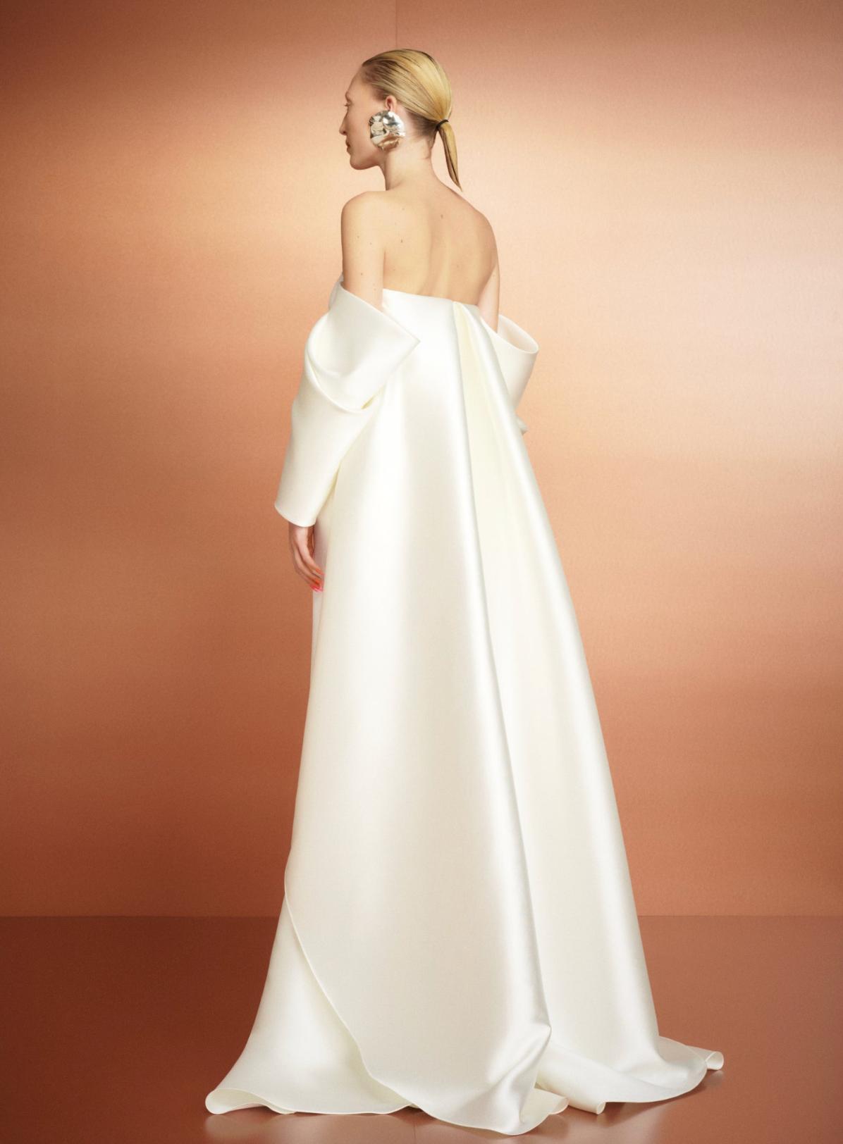 Elegant white satin strapless evening gown with a dramatic court train and off-the-shoulder draped sleeves.