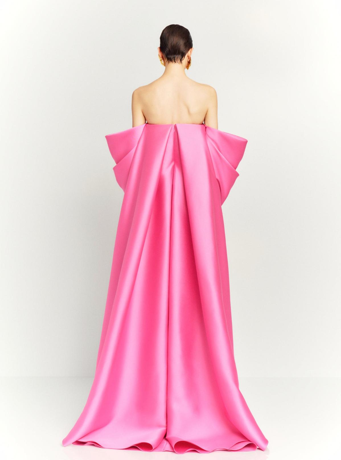 Back view of a strapless hot pink satin evening gown with dramatic draped sleeves and a long court train.