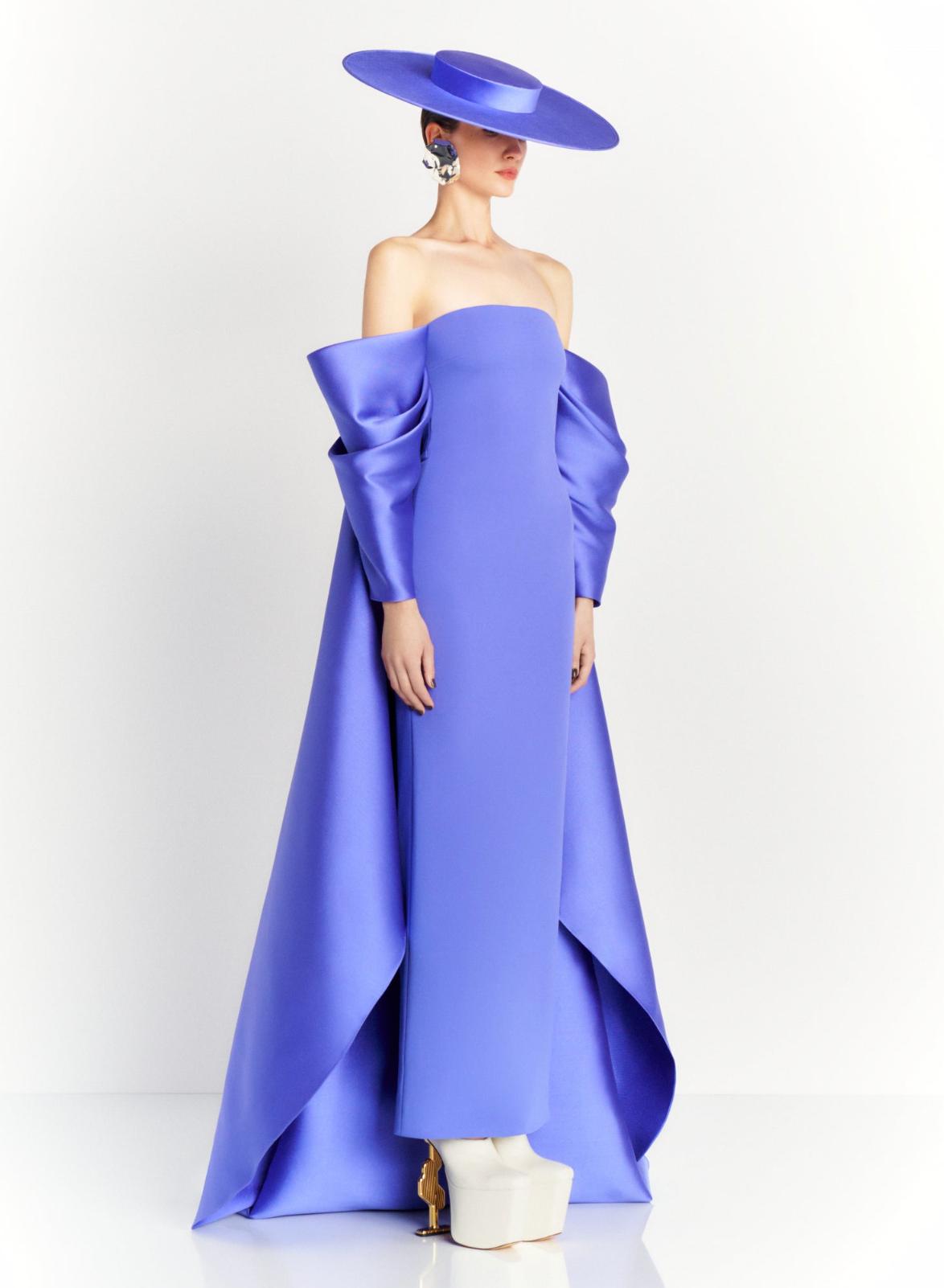 Strapless blue satin evening gown with dramatic draped sleeves, a court train, and a matching wide-brim hat.