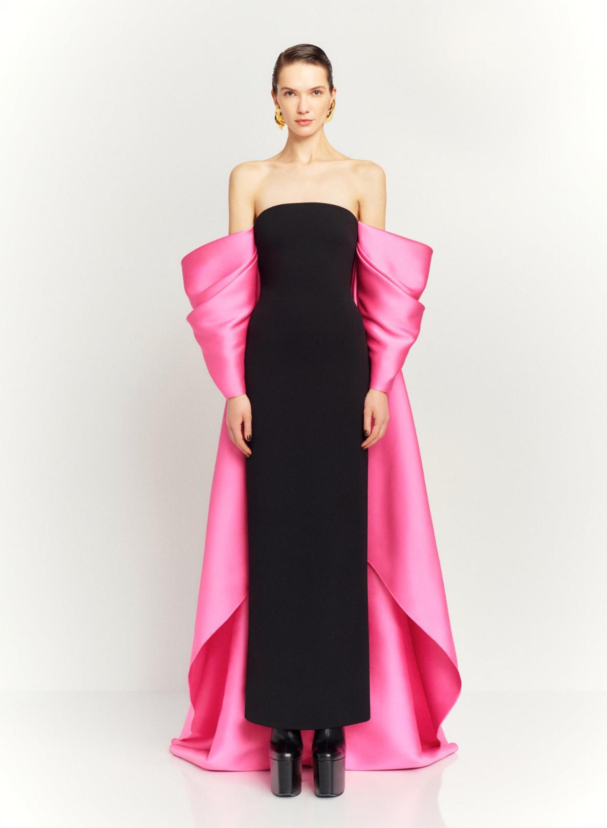 Strapless black satin evening gown featuring dramatic, voluminous pink sleeves and a long court train.