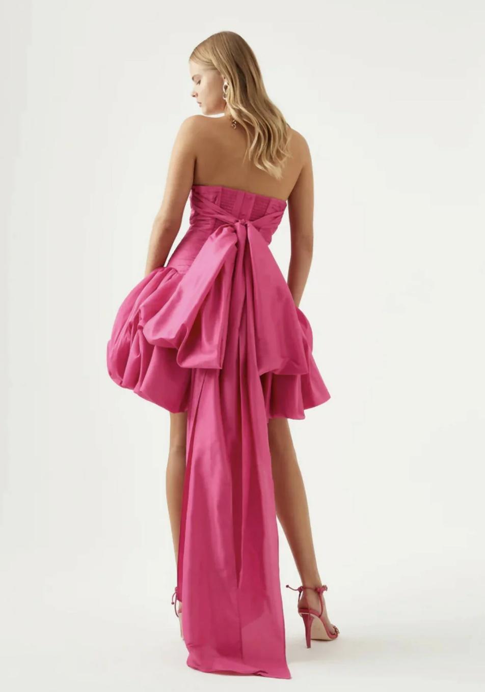 Hot pink strapless taffeta mini dress with a ruched bodice, voluminous bubble hem, and a dramatic oversized back bow.
