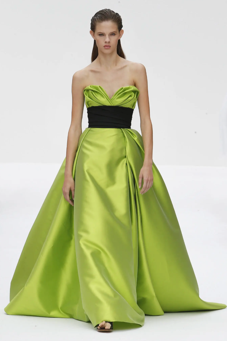 Sleeveless lime green Mikado satin gown with a sculpted sweetheart neckline and a contrasting black waist sash.