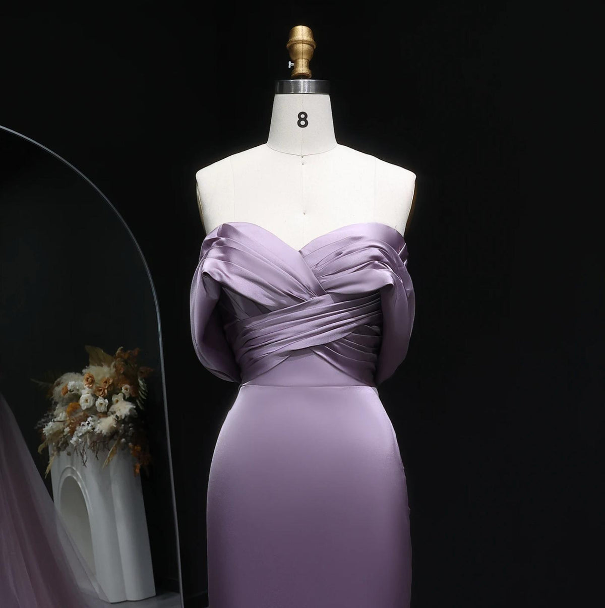 Lavender satin Merribeck mermaid gown with an elegant off-shoulder pleated bodice on a dress form.