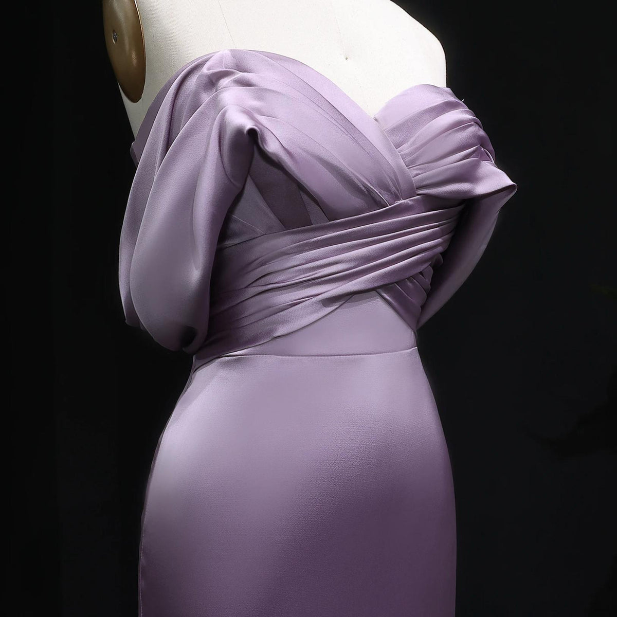Lavender satin off-shoulder mermaid evening gown with elegant bodice pleating on a mannequin.