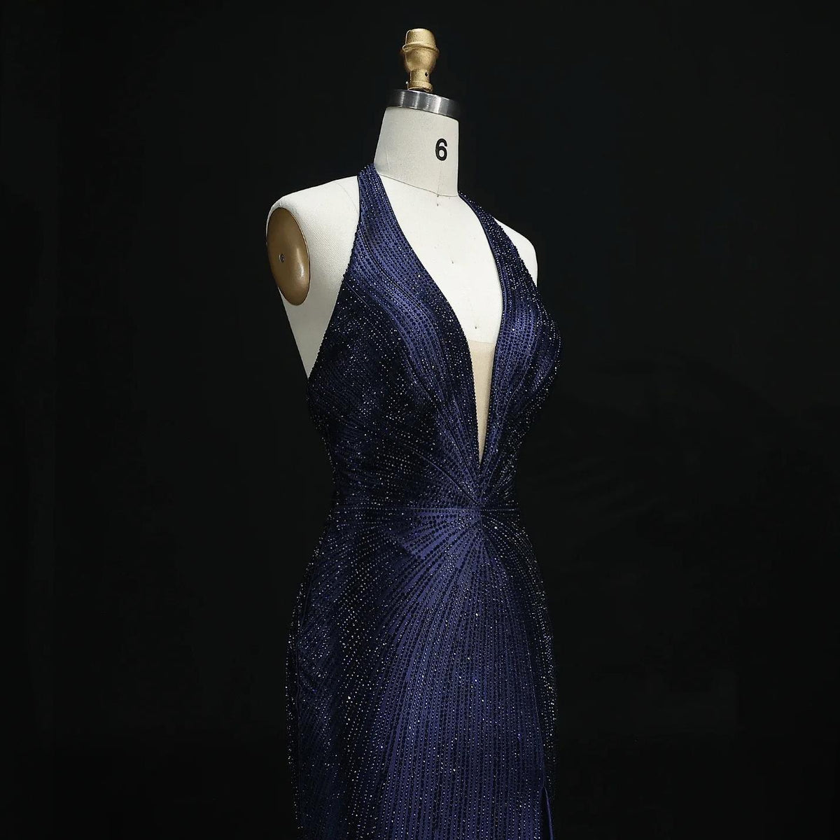Midnight blue satin evening gown with a plunging halter neckline and intricate sparkling crystal embellishments.