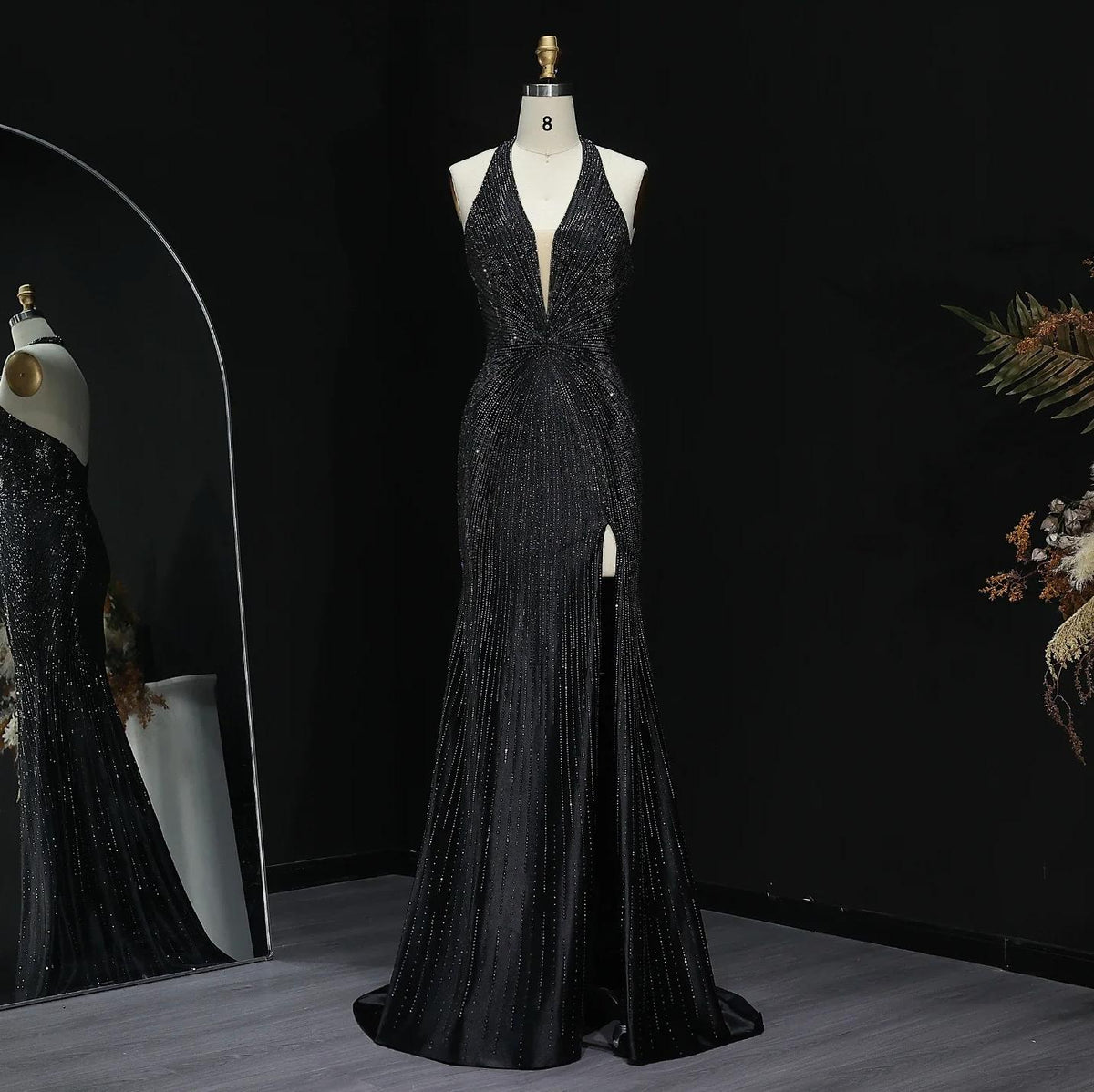 Midnight Soiree black satin evening gown with crystal embellishments, halter neckline, and thigh-high slit on a mannequin.