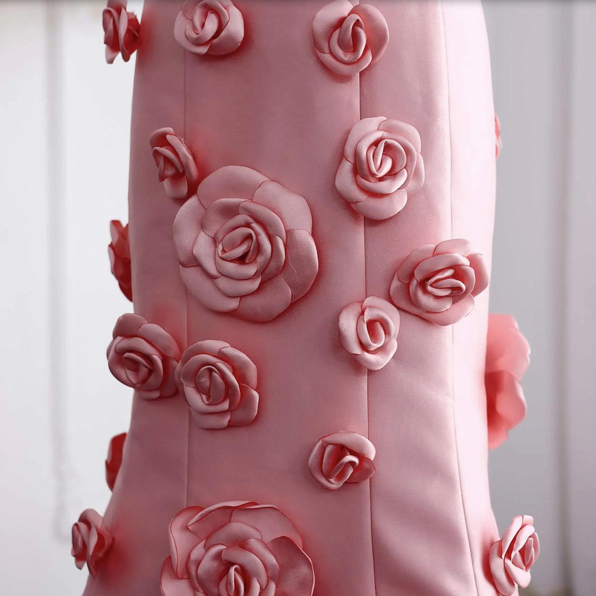 Pink satin mermaid gown featuring cascading 3D floral appliqués and a smooth, elegant finish.