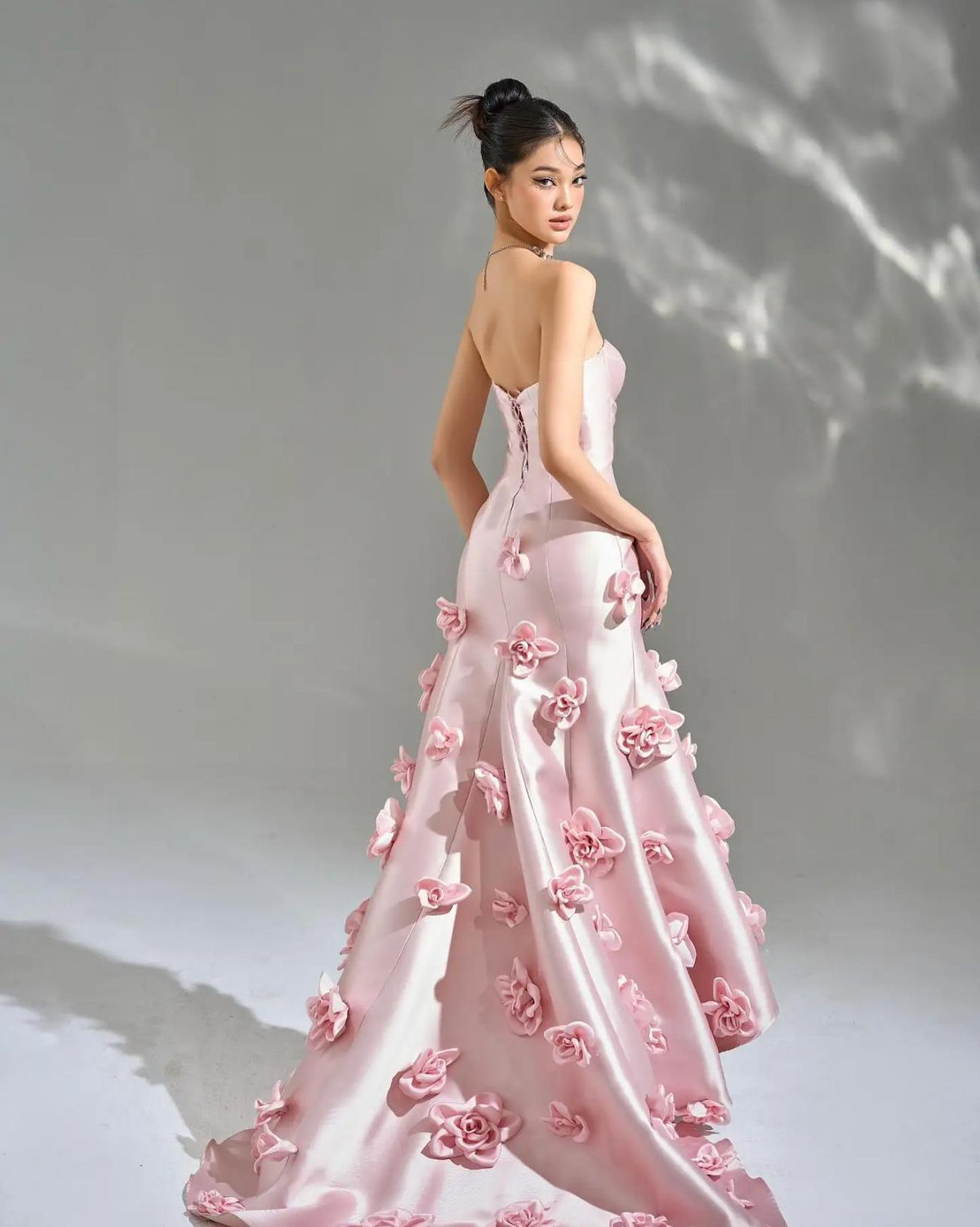 Sleeveless pink satin mermaid gown featuring a sweetheart neckline and cascading 3D floral appliqués.
