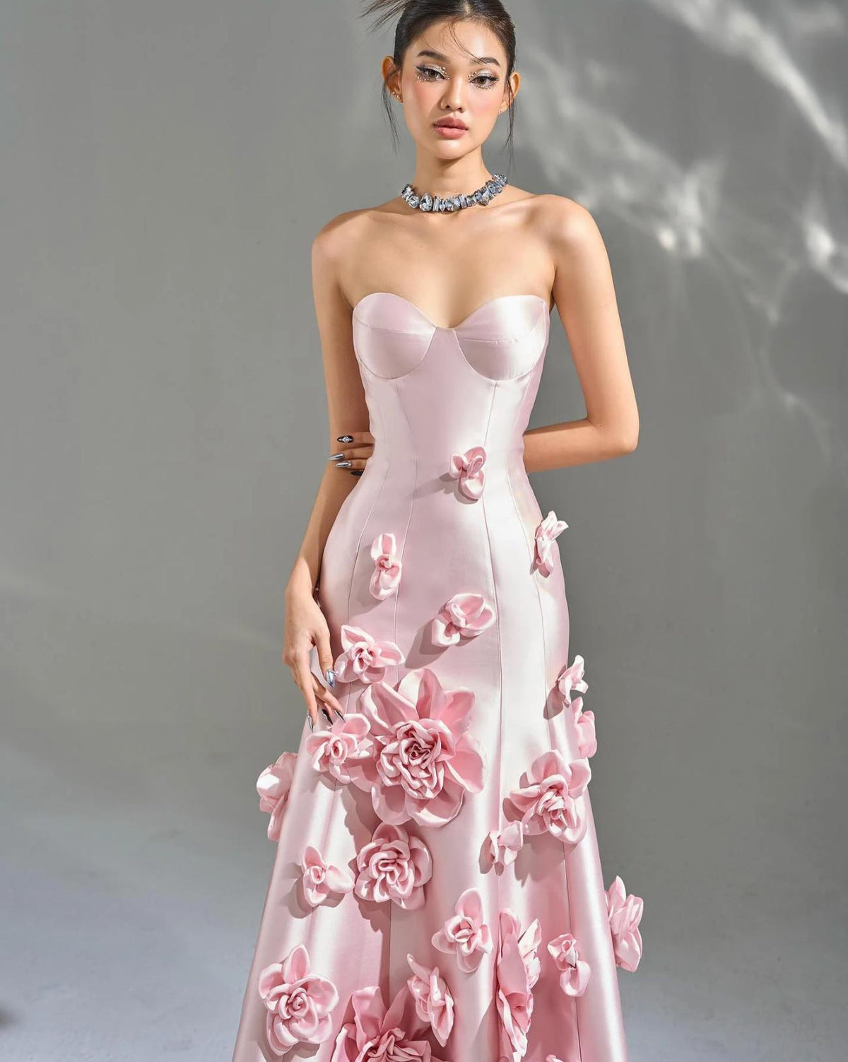 Sleeveless pink satin mermaid gown featuring a sweetheart neckline and cascading 3D floral appliqués.