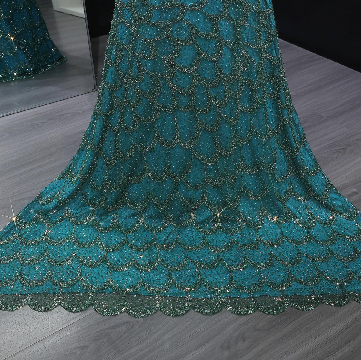 Emerald green mermaid gown featuring intricate scalloped beading and crystal appliqués on luxurious tulle fabric.
