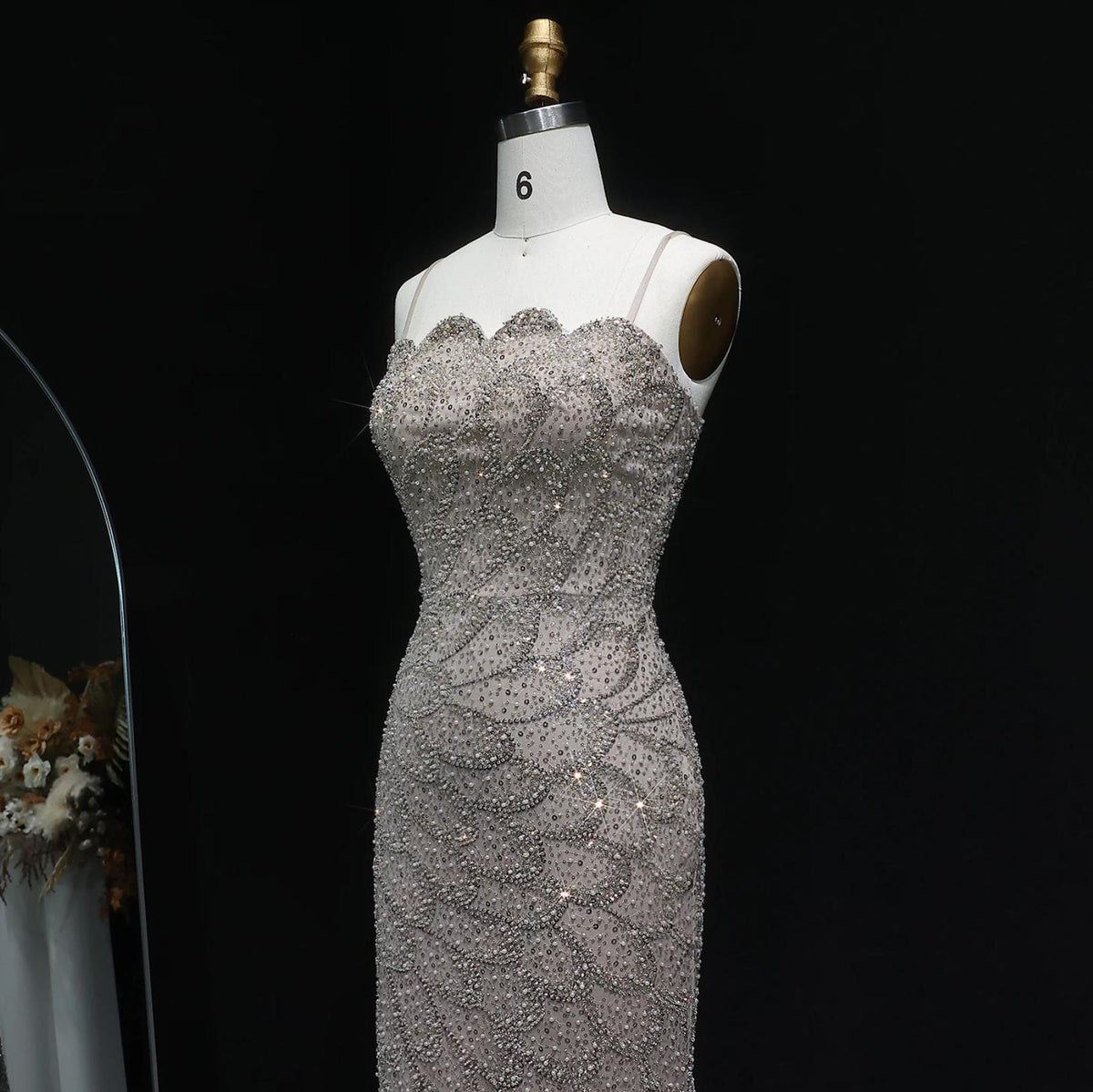 Strapless mermaid gown in shimmering champagne with intricate crystal beading and scalloped neckline on a size 6 mannequin.