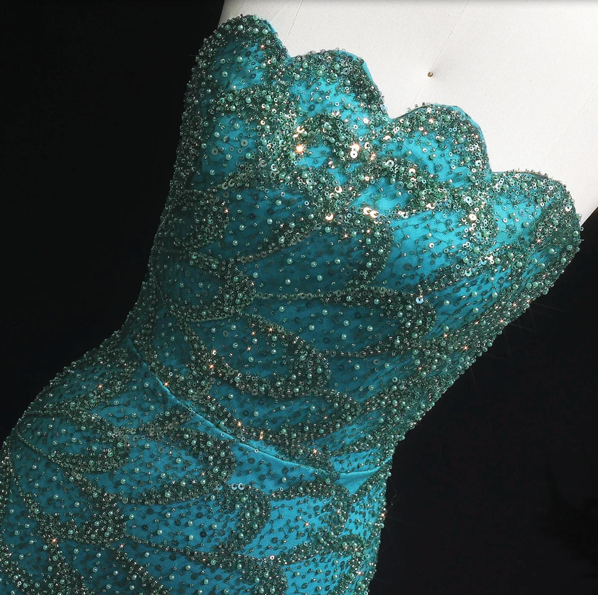 Emerald green strapless mermaid gown with intricate crystal beading and sequin appliqués on tulle and satin fabric.