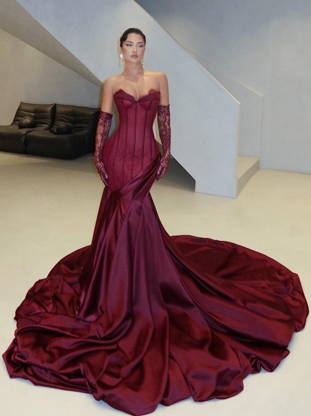 Burgundy satin corset gown with sweetheart neckline, lace detailing, side draping, floor-sweeping train, and matching gloves.
