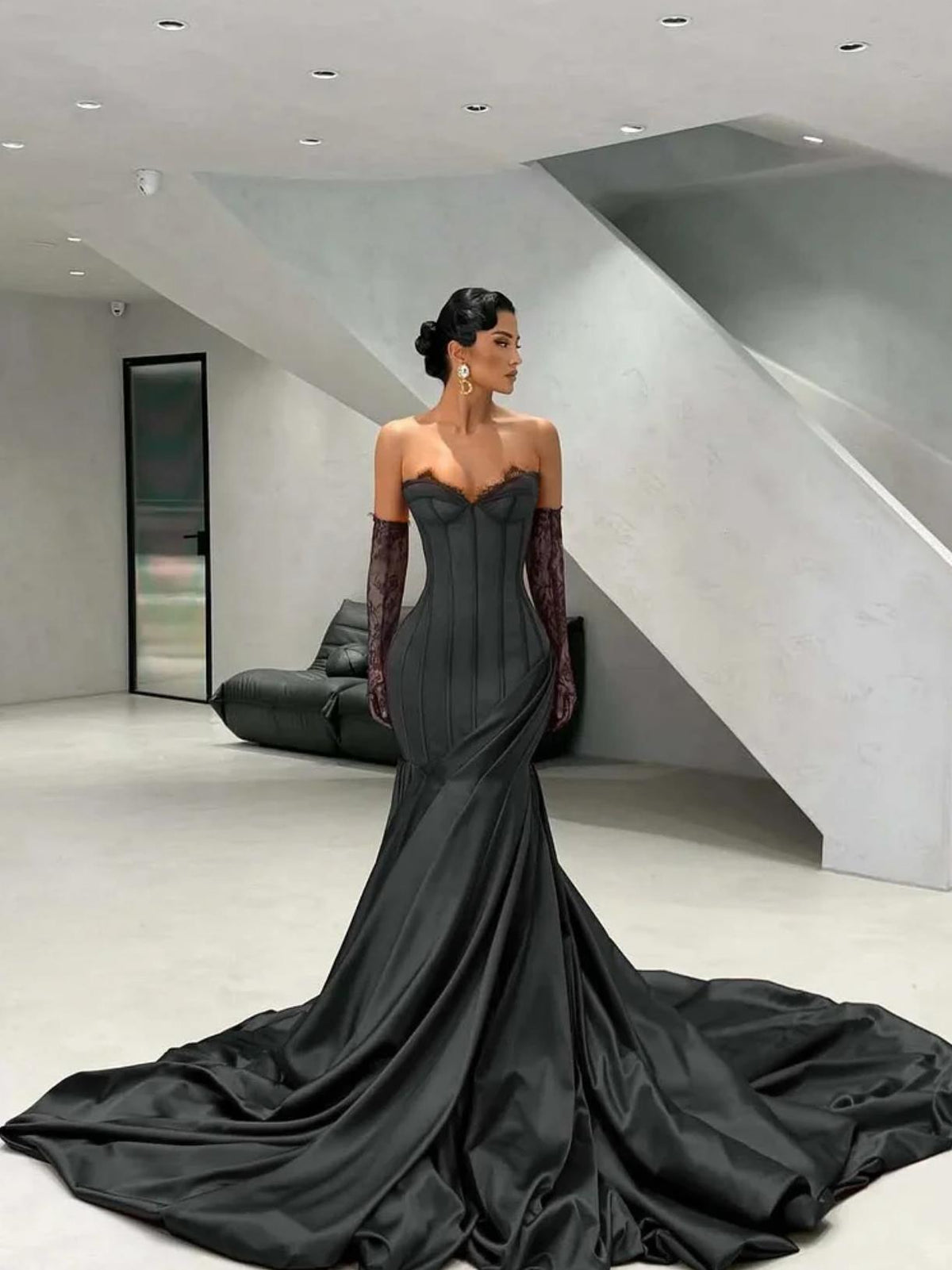 Black satin corset gown with sweetheart neckline, lace detailing, and matching opera gloves with a floor-sweeping train.