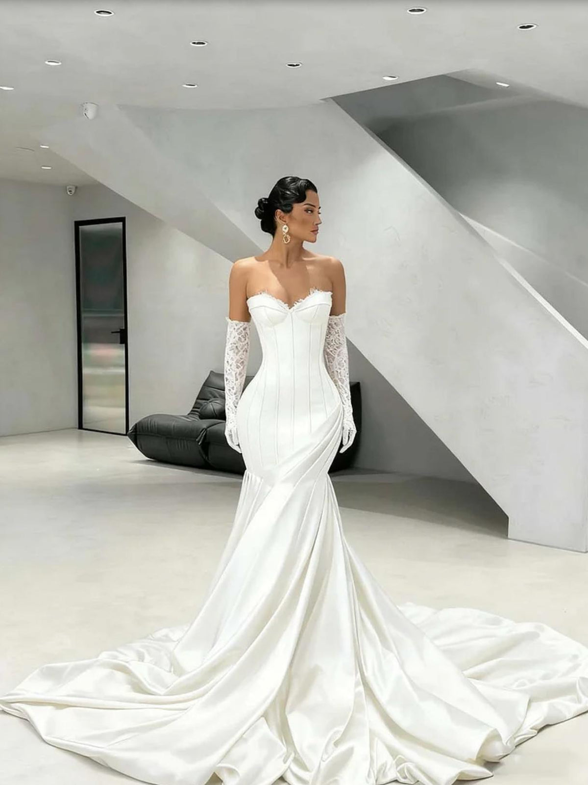 White satin corset gown with sweetheart neckline, lace gloves, and a dramatic floor-sweeping train.