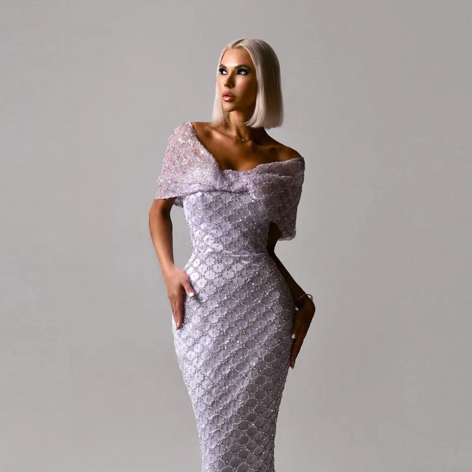 Lavender off-the-shoulder mermaid gown with a beaded lattice pattern, draped cap sleeves, and a structured bodice.