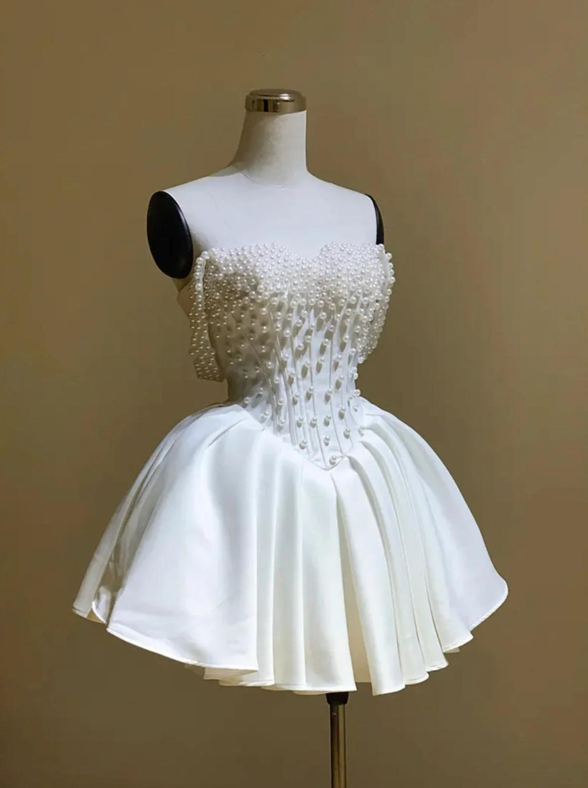 White silk mini bridal dress with an off-the-shoulder neckline, corset bodice, and delicate pearl embellishments.