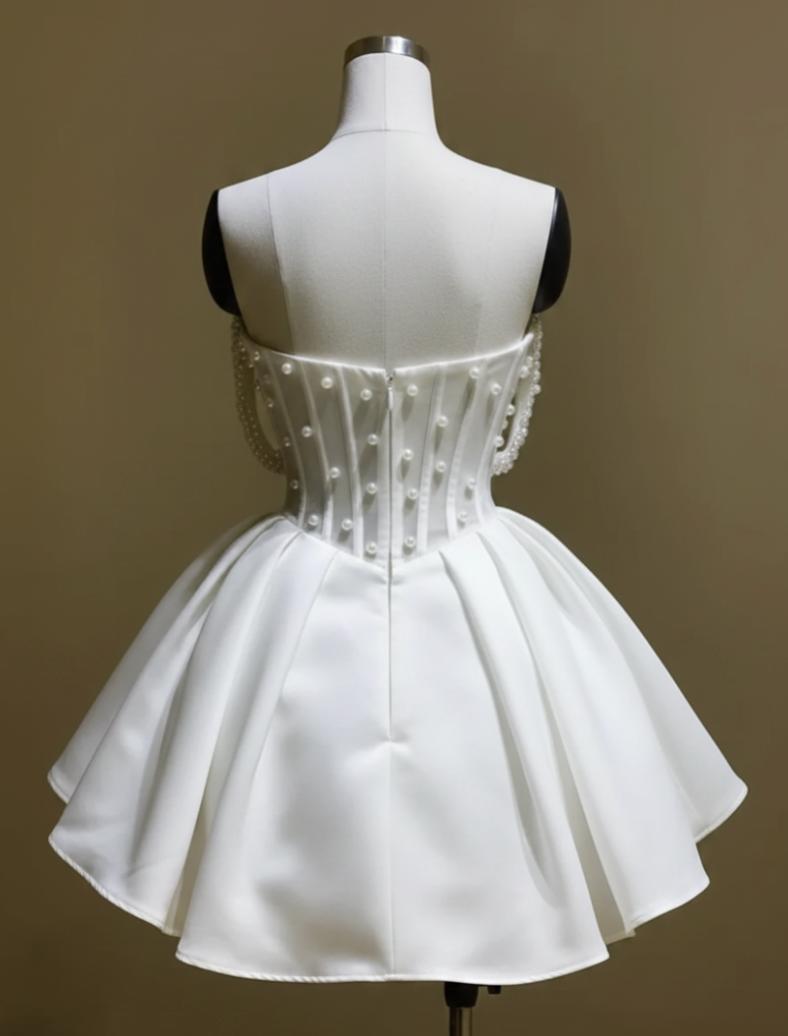 White silk A-line bridal mini dress with off-the-shoulder neckline and delicate pearl embellishments on a mannequin.