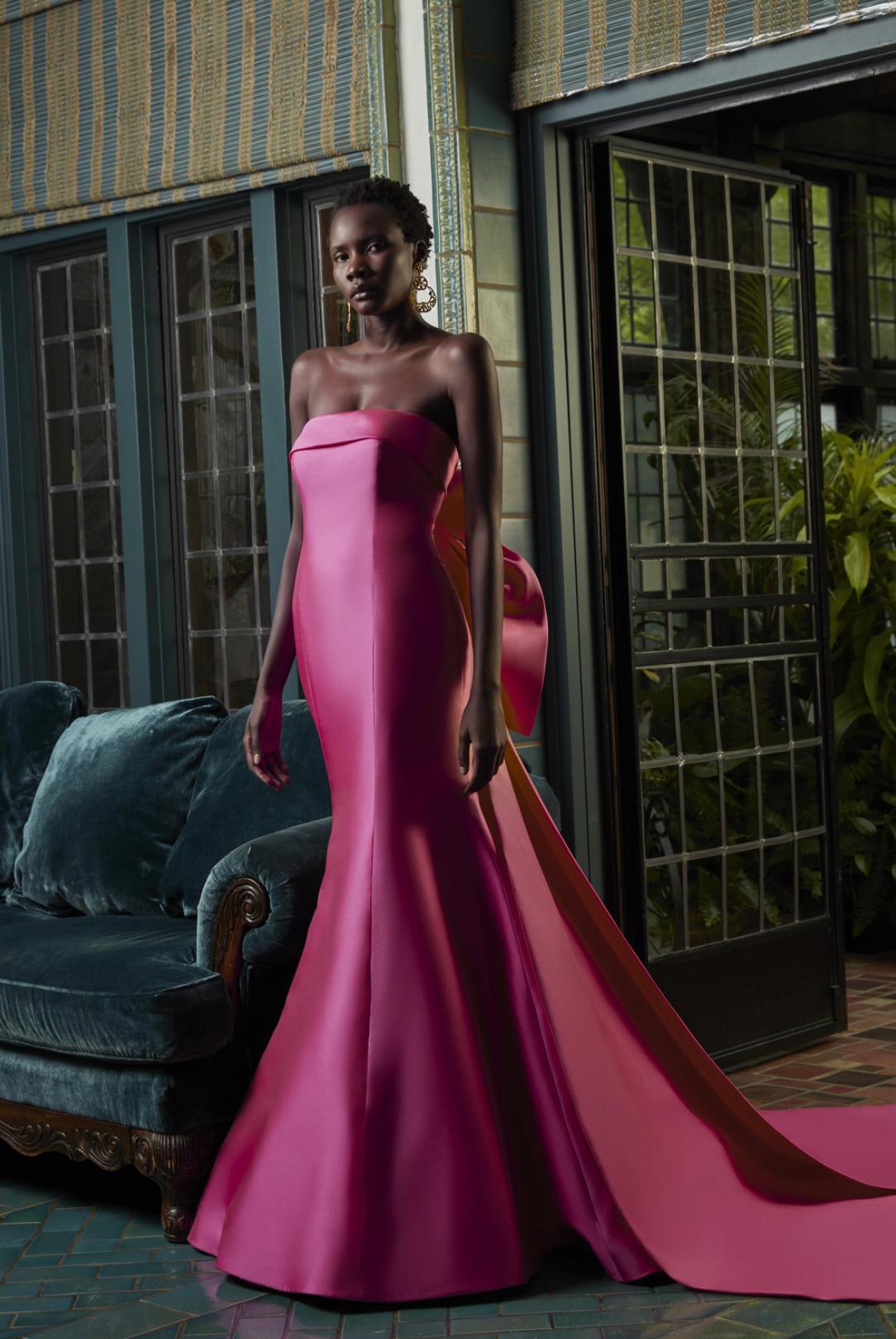 Hot pink Mikado satin gown with a straight neckline, tailored collar, and a dramatic detachable back bow.