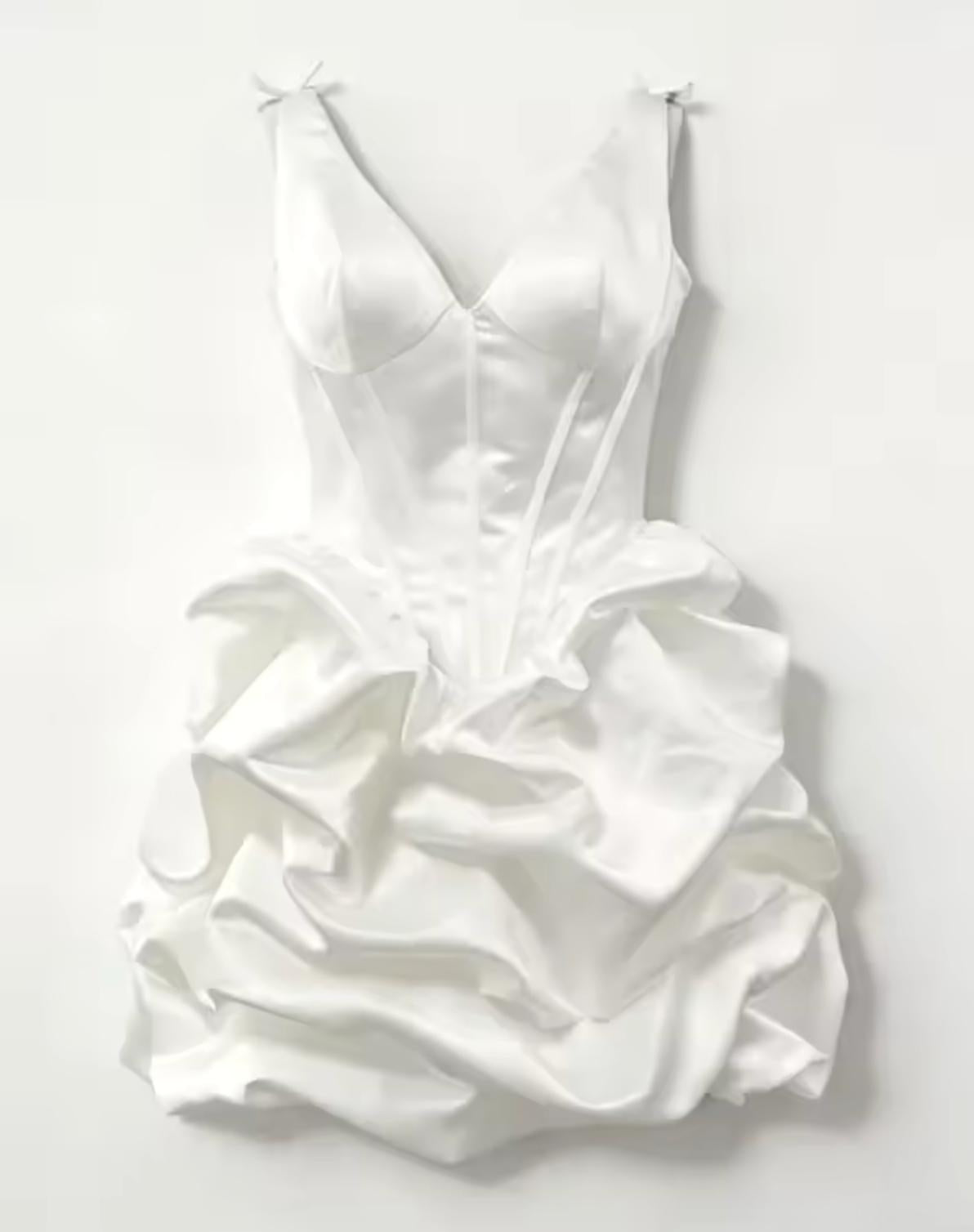 White satin mini dress with a plunging V-neckline, corset bodice, and voluminous pleated A-line skirt.