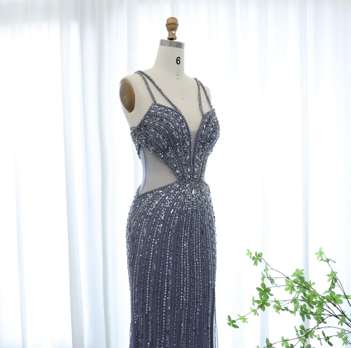 Grey mermaid evening gown with V-neck, spaghetti straps, and intricate crystal and sequin beadwork on tulle.