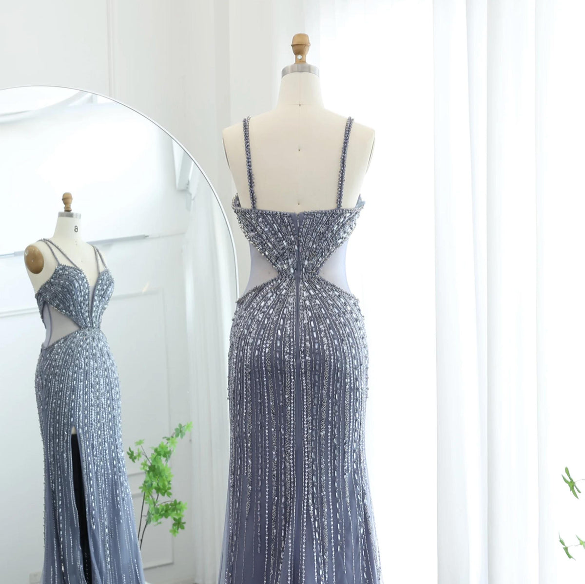 Nude mermaid evening gown with intricate silver beading, sequins, spaghetti straps, and a high slit on a mannequin.