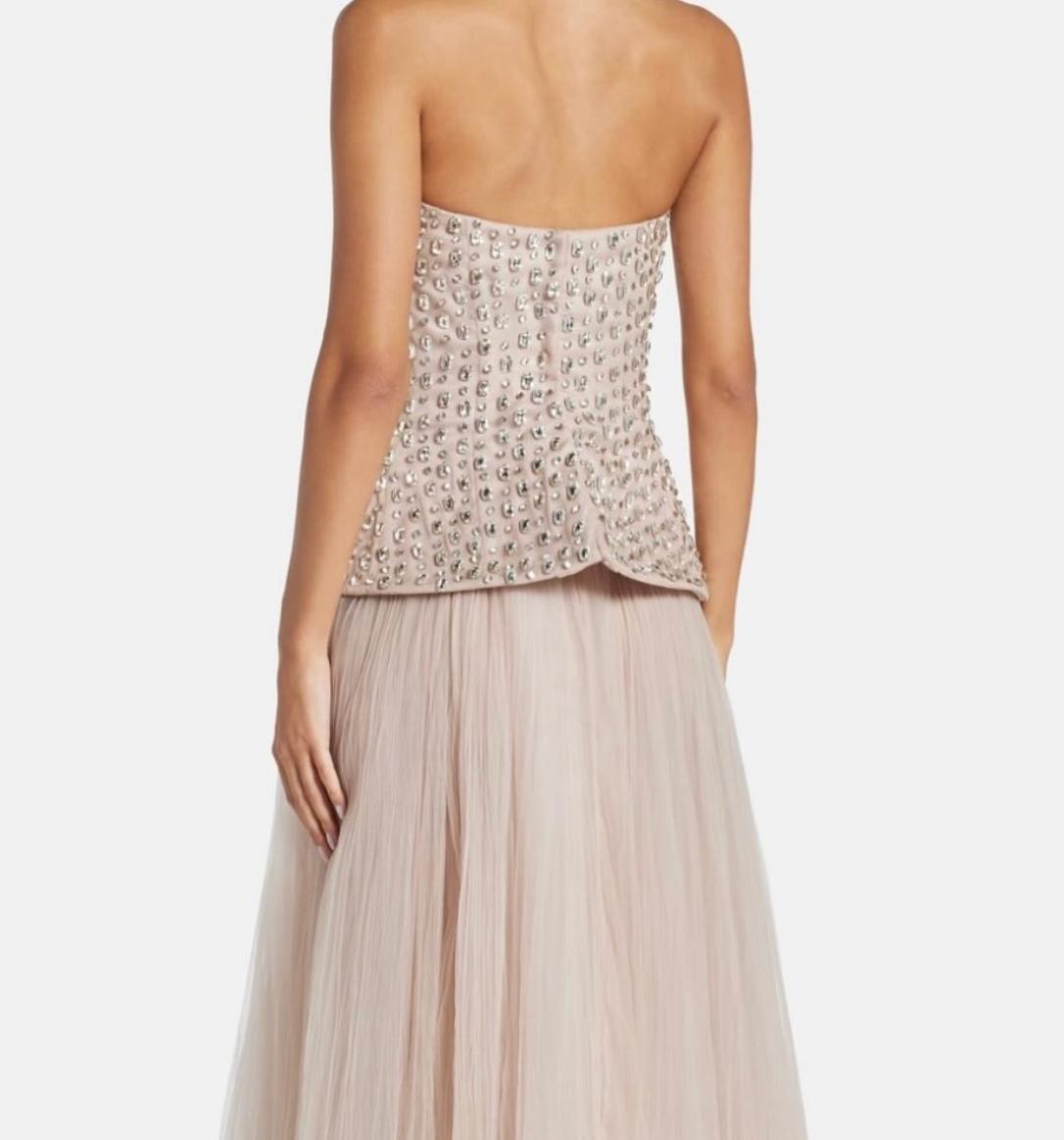 Strapless Putu Gede gown featuring a crystal-embellished corseted bodice, peplum waist, and a flowing pleated skirt.