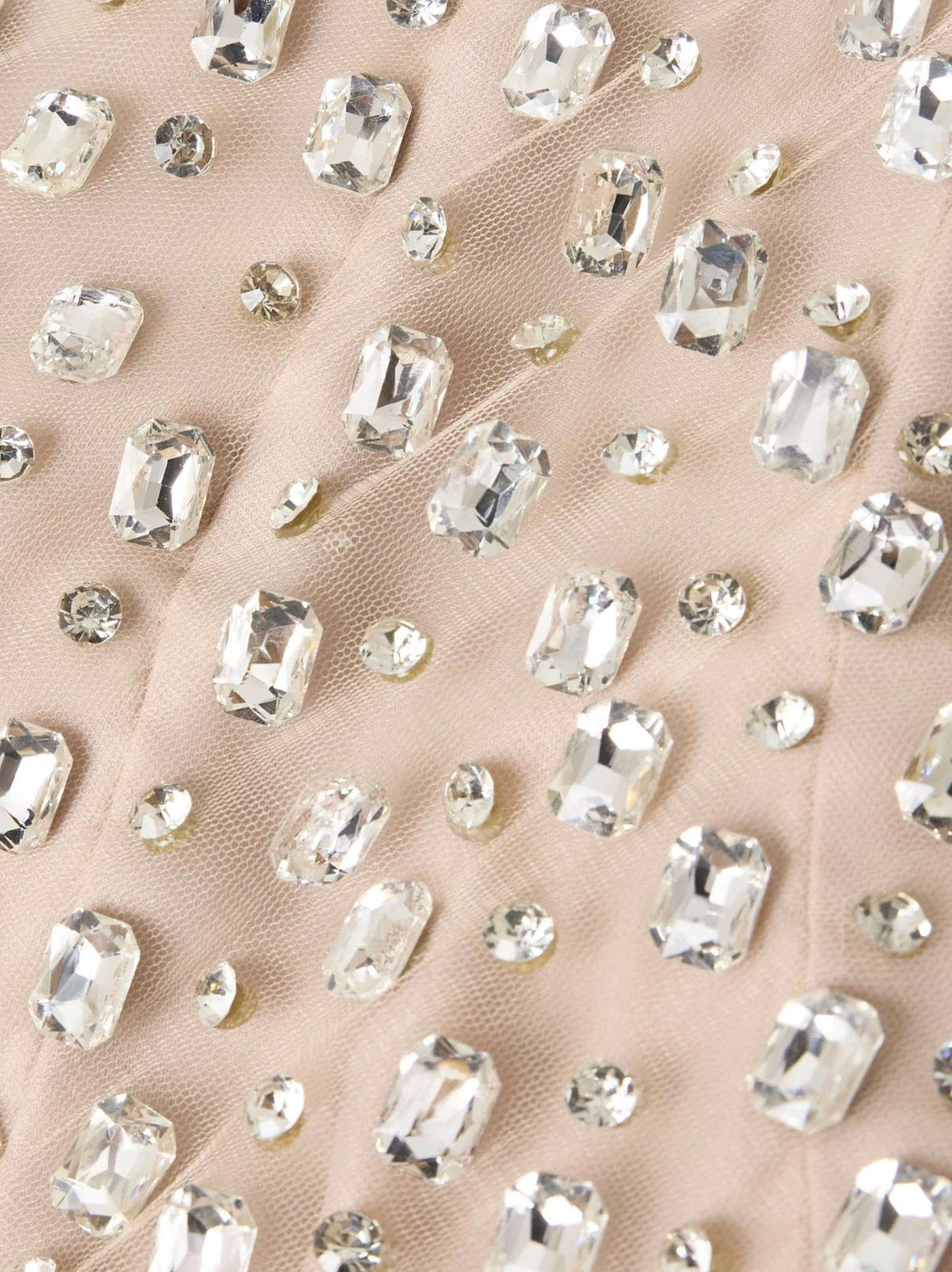 Nude illusion tulle fabric embellished with sparkling rectangular and round diamond-like crystals.