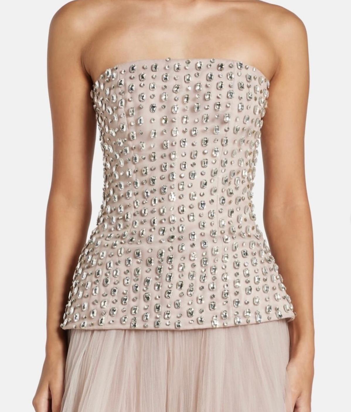 Strapless Putu Gede gown featuring a corseted bodice with crystal-embellished stone lace and a peplum silhouette.