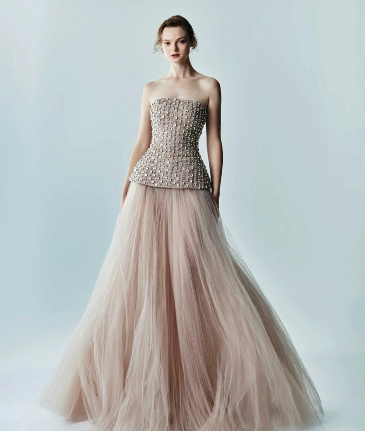 Strapless Putu Gede gown featuring a crystal-embellished corseted bodice, peplum waist, and a flowing tulle skirt.