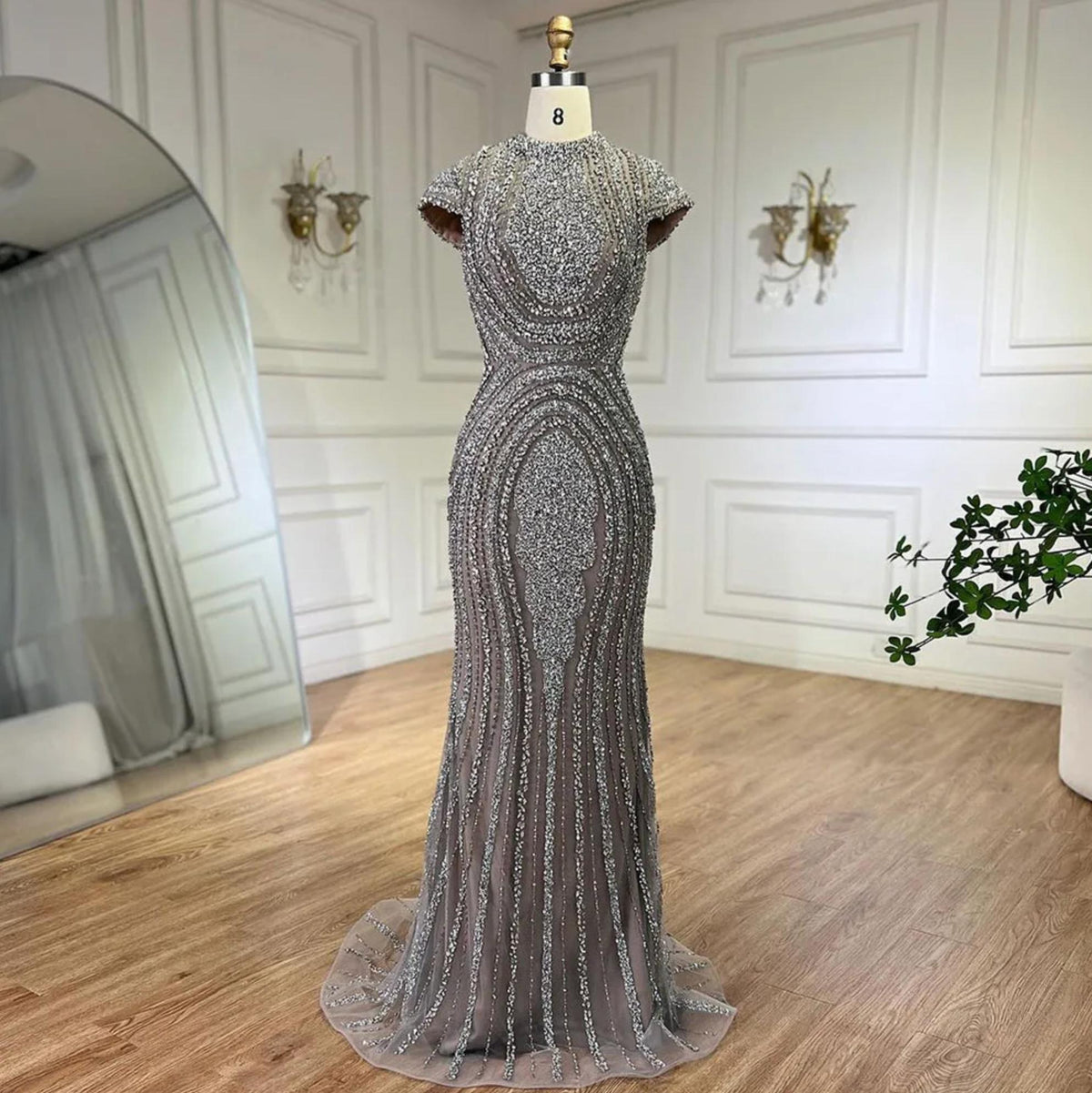 Gray nude mermaid evening gown with intricate silver beading, short sleeves, and a floor-length tulle trumpet silhouette.
