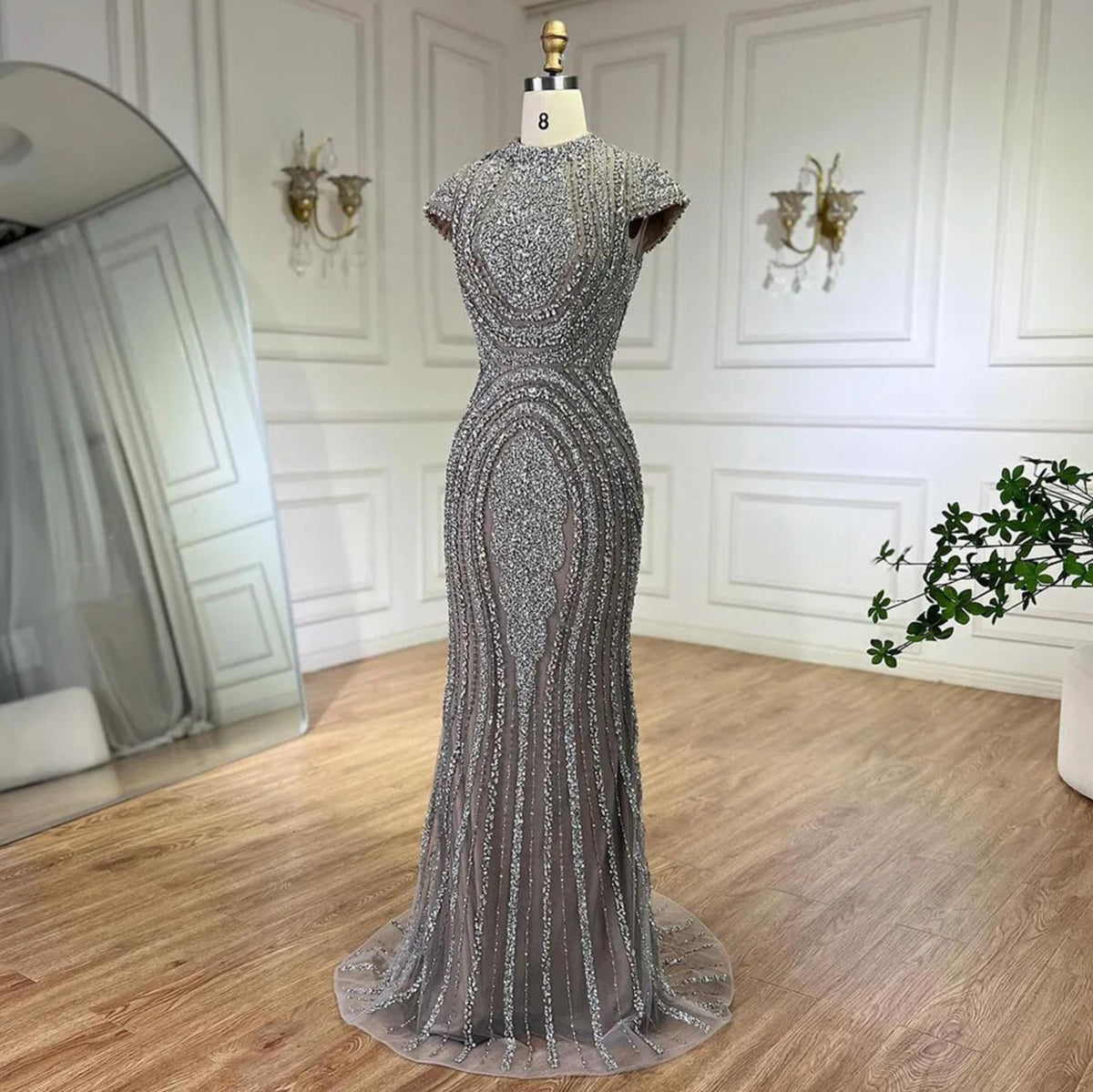 Gray nude mermaid evening gown with intricate silver beading on tulle, short sleeves, and a floor-length trumpet silhouette.