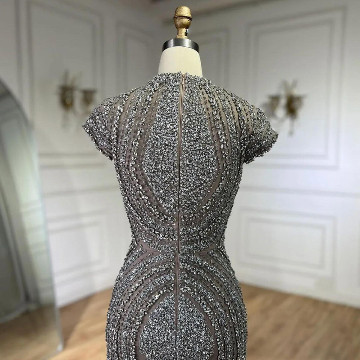 Gray nude mermaid evening gown featuring intricate silver beading on tulle with short sleeves and a round neckline.