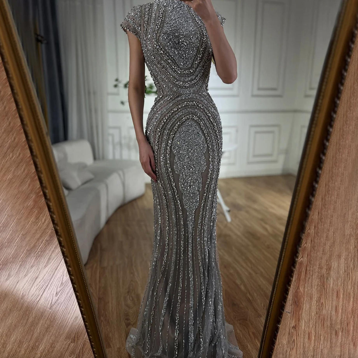 Gray nude mermaid gown with intricate silver beading on tulle, featuring short sleeves and a floor-length trumpet silhouette.