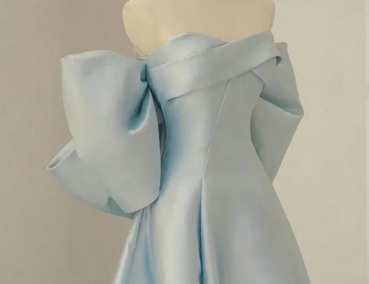 Light blue satin Regina gown with an off-the-shoulder neckline and dramatic oversized bow sleeves on a mannequin.