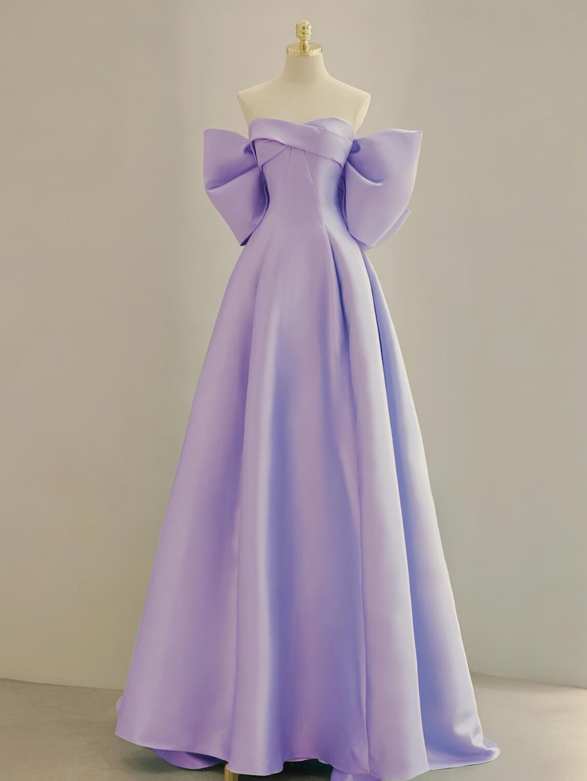 Lavender satin A-line Regina gown with a strapless boat neckline and dramatic oversized bow sleeves on a mannequin.