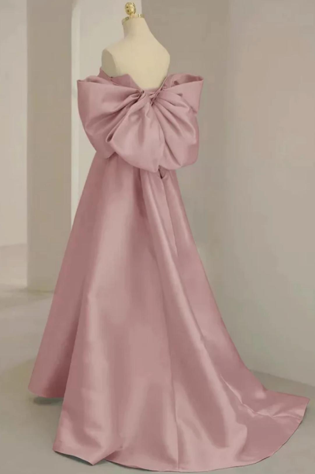 Dusty pink satin A-line evening gown featuring a strapless neckline and a large statement bow on the back.