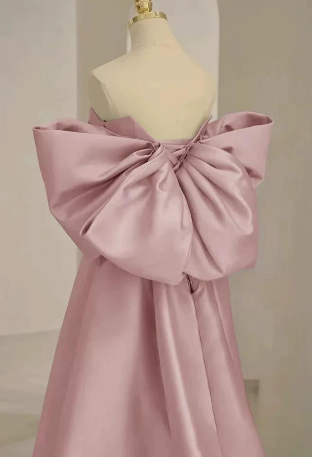 Dusty pink satin Regina gown featuring an oversized back bow, strapless neckline, and elegant A-line silhouette.