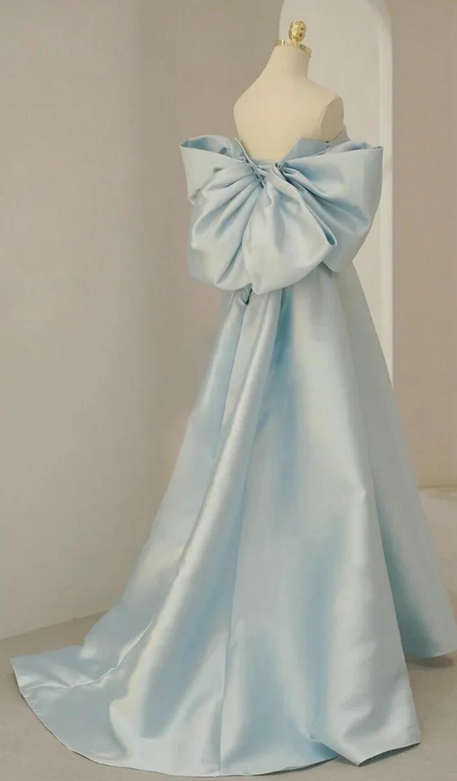 Light blue satin Regina gown with a strapless bodice, off-the-shoulder boat neckline, and a large statement bow on the back.
