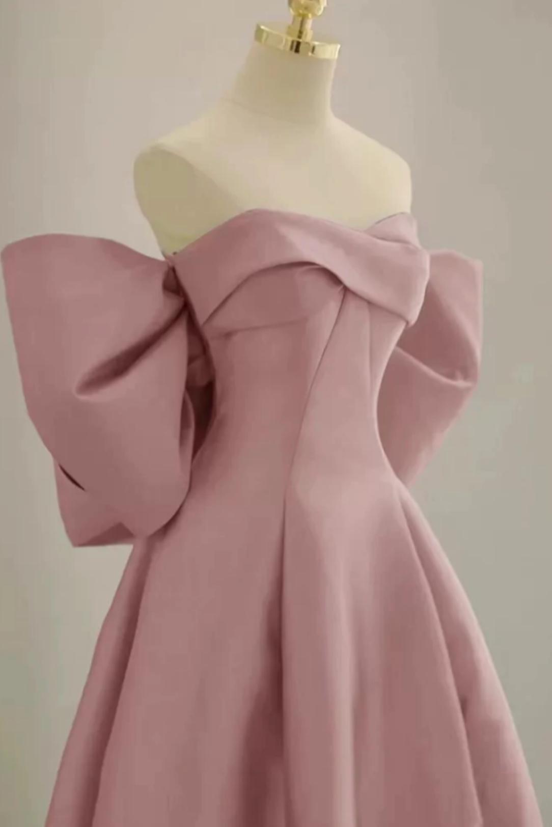 Dusty pink satin A-line gown with a strapless boat neckline and dramatic oversized bow sleeves on a mannequin.