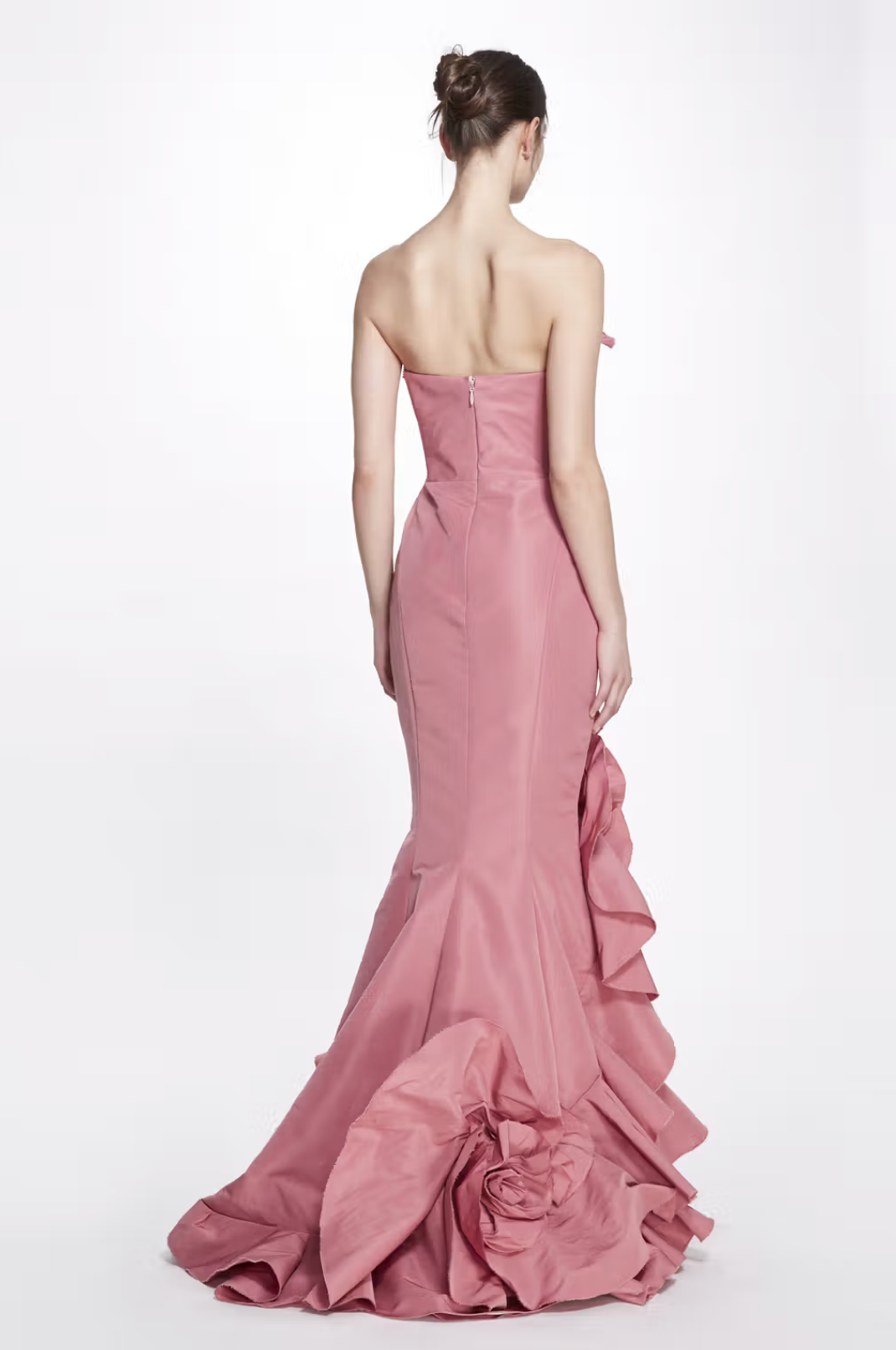 Back view of a dusty pink faille Rosetta gown featuring a fitted bodice, structured seaming, and a 3D flower detail on the hem.